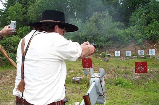 Sue shooting pistol from his horse.