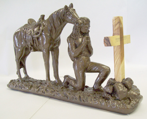 Cowgirl praying at cross.