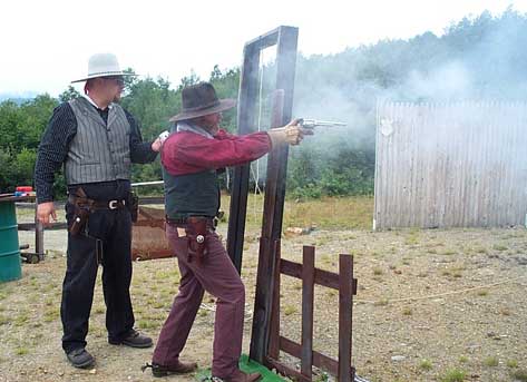 Shooting pistol at Dalton Shoot while being timed by Jake Mountain.