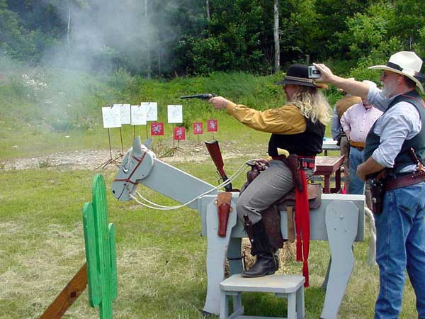 Shooting his open-top pistol.