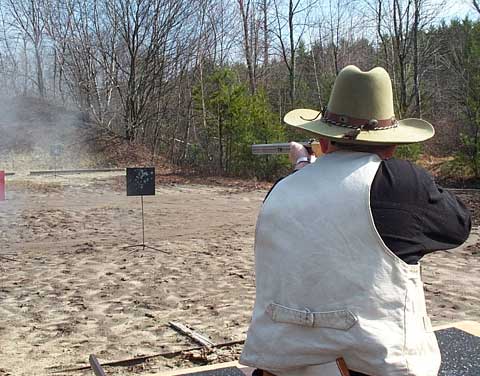 Blazing away with his rifle.